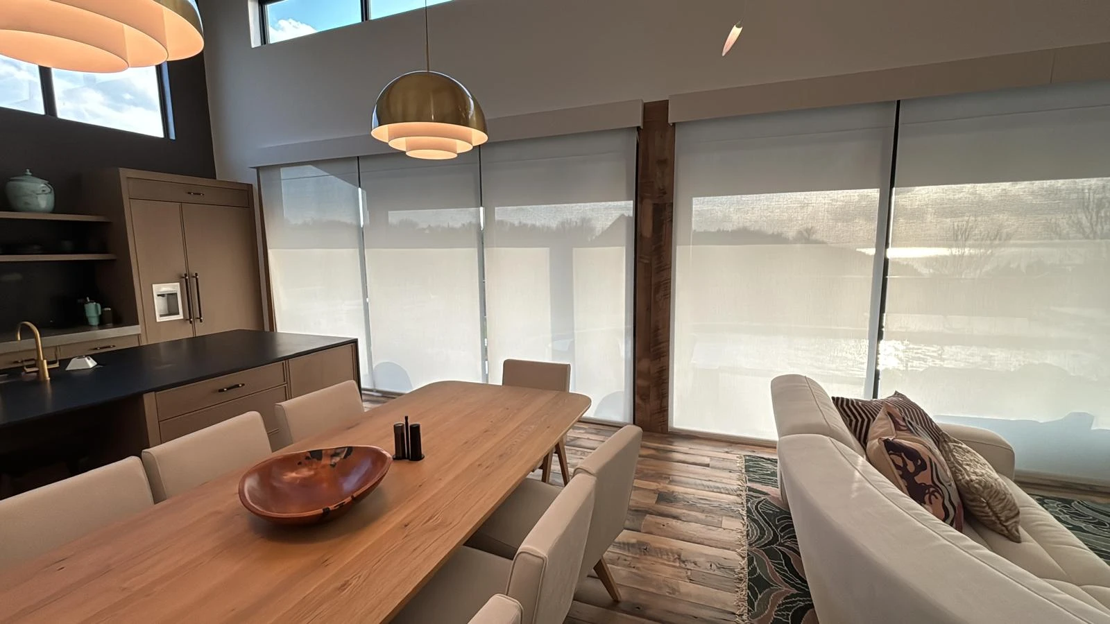 Dining room with motorized roller shades on large windows